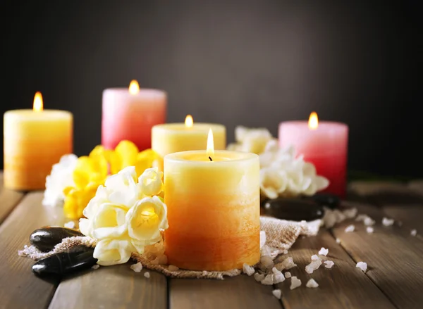 Hermosas velas con flores sobre fondo de madera — Foto de Stock