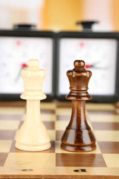 Tablero de ajedrez con ajedrez y reloj sobre fondo claro — Foto de Stock