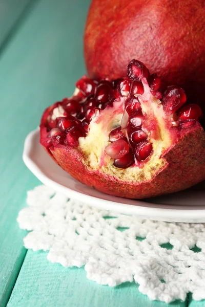 Rijp Granaatappels op plaat, op een houten achtergrond kleur — Stockfoto