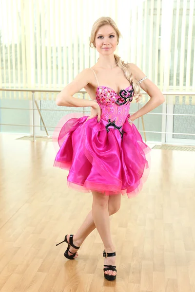 Schöne Frau in rosa Kleid tanzt im Saal — Stockfoto