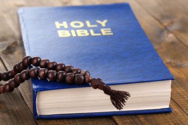 Bible with cross on wooden table close-up clipart