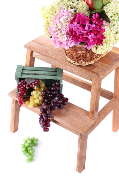 Weidenkorb mit Blumen und Früchten in Holzkiste, auf kleiner Holzleiter, isoliert auf weiß — Stockfoto