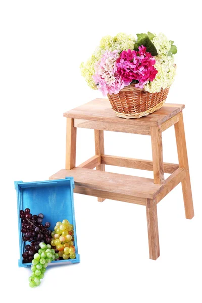 Proutěný košík s květy a ovoce v dřevěné krabici, na malý dřevěný žebřík, izolované na bílém — Stock fotografie
