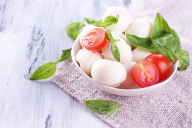 kase, ahşap masa üstünde domates ve fesleğen ile lezzetli mozzarella peyniri