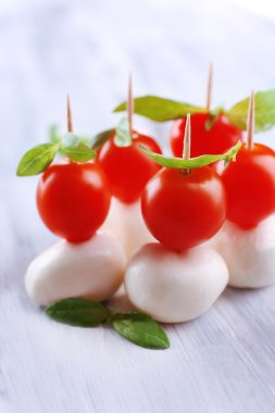 ahşap masa üstünde domates ve fesleğen ile lezzetli mozzarella peyniri