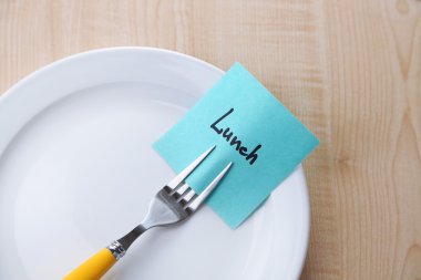 Not kağıdı ile mesaj ahşap arka plan üzerinde plaka üzerinde çatal bağlı