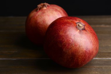 Masanın üzerinde olgun narlar var.