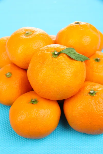 Rijpe zoete mandarijnen, op een achtergrond met kleur — Stockfoto