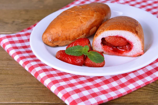 Frisch gebackenes Gebäck mit Erdbeeren auf Teller in Großaufnahme — Stockfoto