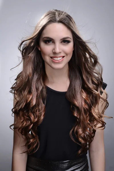 Gyönyörű fiatal nő, hosszú haj, a szürke háttér — Stock Fotó
