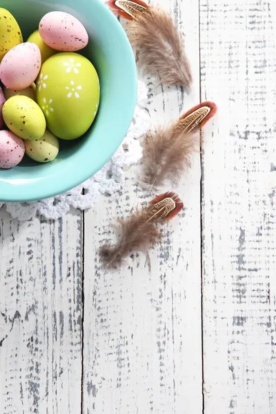 Uova di Pasqua in ciotola a colori su sfondo di legno a colori — Foto Stock