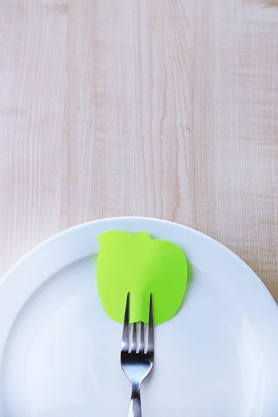 Lege nota papier gekoppeld aan vork, op de plaat, op een houten achtergrond kleur — Stockfoto