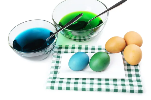 Cuencos con pintura para huevos de Pascua y huevos, aislados en blanco — Foto de Stock