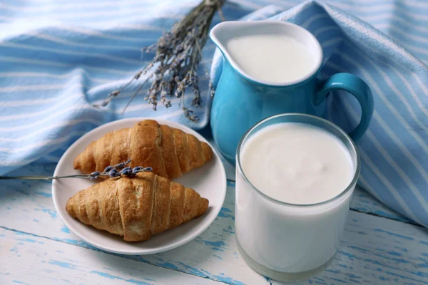 Homemade yogurt in jug and tasty croissants on wooden table background — Stock Photo, Image