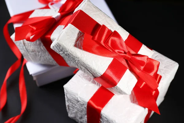 Hermosos regalos con cintas rojas, sobre fondo oscuro —  Fotos de Stock