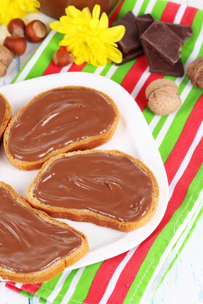 Bread with sweet chocolate hazelnut spread on plate on table — Stock Photo, Image