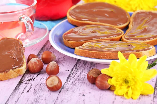 Pane con cioccolato dolce alla nocciola spalmato sul piatto sul tavolo — Foto Stock