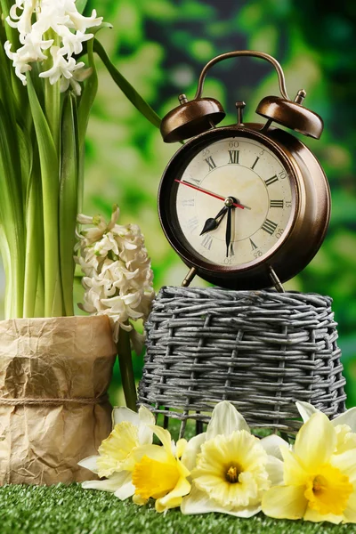 Reloj despertador sobre hierba verde, sobre fondo natural — Foto de Stock