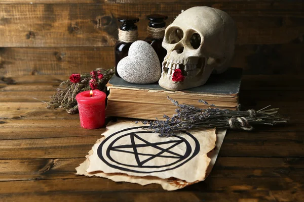 Conceptual photo of love magic. Composition with skull, dried herbs and candle on  dark wooden background — Stock Photo, Image