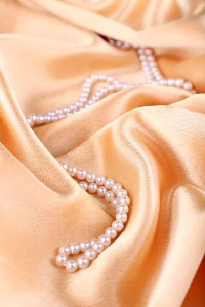 Mooie parels op gouden zijden doek — Stockfoto