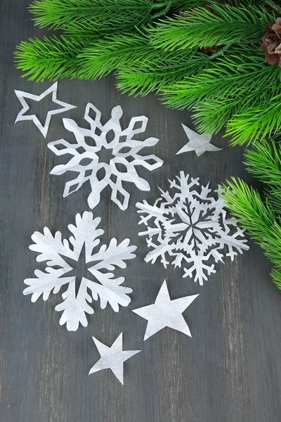 Beautiful snowflakes with fir branch on wooden background — Stock Photo, Image