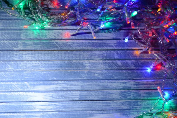 Christmas lights on wooden background — Stock Photo, Image