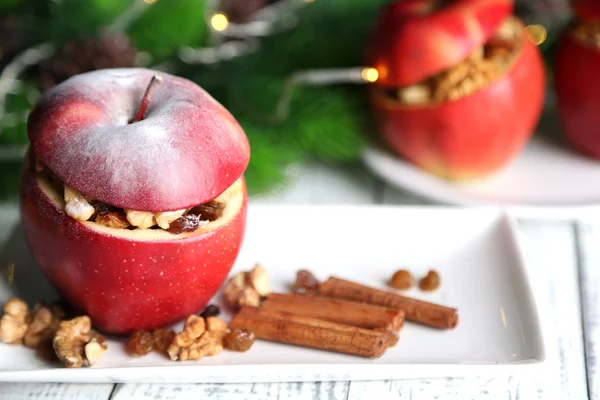 Masanın üzerinde fındık ve kuru üzüm ile doldurulmuş yılbaşı elma kadar yakın — Stok fotoğraf