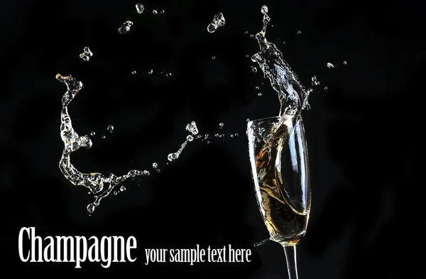 Sticlă de șampanie cu stropire, pe fundal negru — Fotografie, imagine de stoc