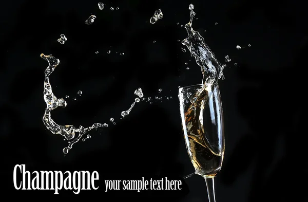 Glas champagne met splash, op zwarte achtergrond — Stockfoto