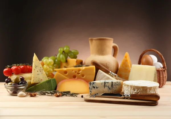 Tasty dairy products on wooden table, on dark background — Stock Photo, Image