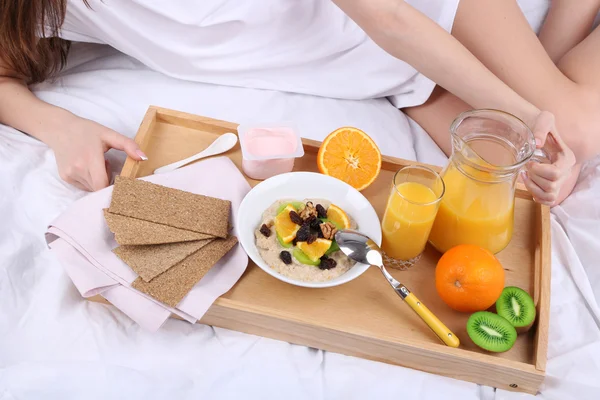 Kvinde i seng med let morgenmad - Stock-foto