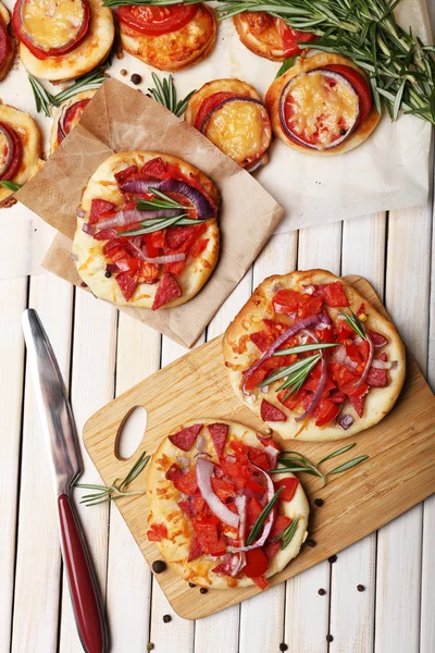 Small pizzas on baking paper close up — Stock Photo, Image