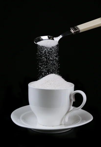 Suiker in cup geïsoleerd op zwart — Stockfoto