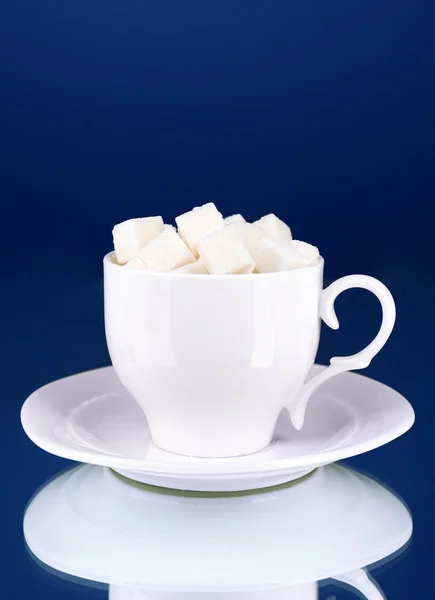 Sugar in cup on blue background — Stock Photo, Image