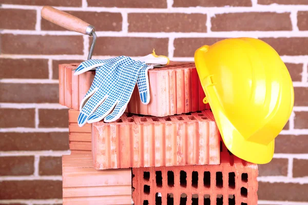 Nuevos ladrillos y herramientas de construcción sobre fondo de pared de ladrillo —  Fotos de Stock