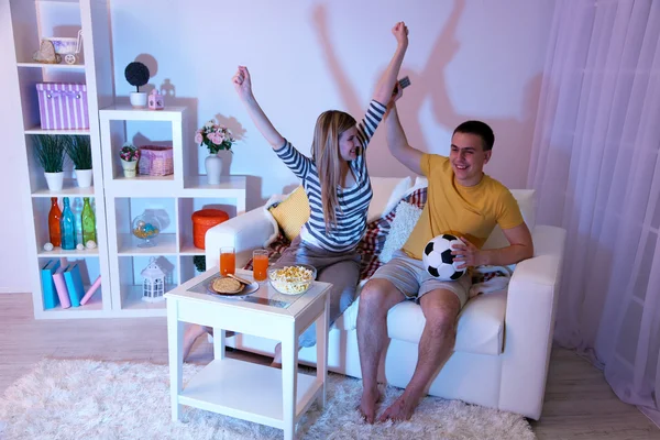 Young couple watching television at home of blacking-out — Stock Photo, Image