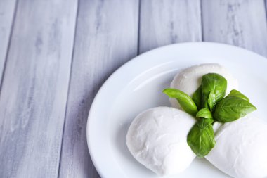 lezzetli mozzarella peyniri Fesleğenli ahşap zemin üzerinde plaka üzerinde