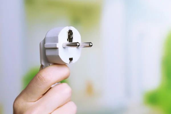 Tapón eléctrico de mano sobre fondo natural —  Fotos de Stock