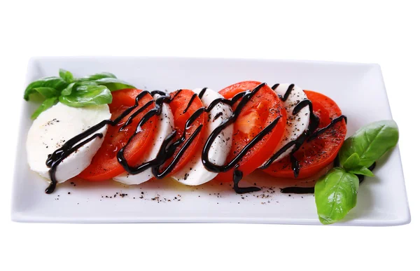 Salada Caprese com queijo mozarella, tomate e manjericão em prato, isolado em branco — Fotografia de Stock