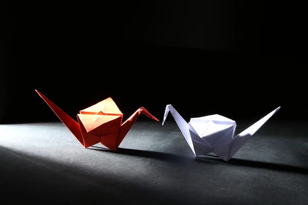 Origami jeřáb na tmavém pozadí se světlem — Stock fotografie