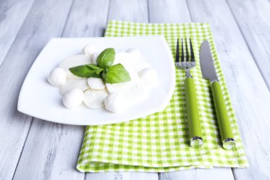 lezzetli mozzarella peyniri Fesleğenli ahşap zemin üzerinde plaka üzerinde