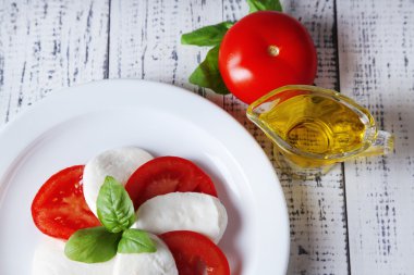 mozarella peyniri, domates ve fesleğen ahşap masa arka plaka Caprese salatası