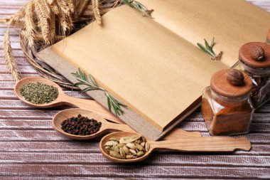 farklı baharatlar ve tahta masada yemek kitabı kapat