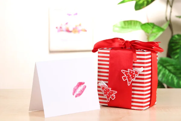 Подарунок з карткою для коханої людини на столі на фоні кімнати — стокове фото