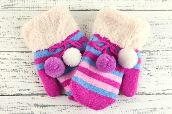 Striped mittens on wooden background — Stock Photo, Image