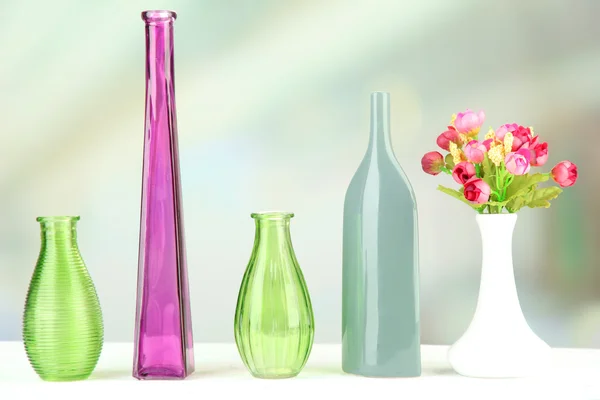 Olika dekorativa vaser på hyllan på ljus bakgrund — Stockfoto