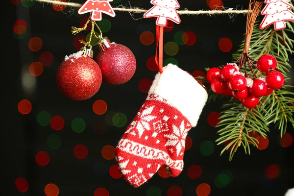 Santa mitten and Christmas accessories on black background with lights — Stock Photo, Image