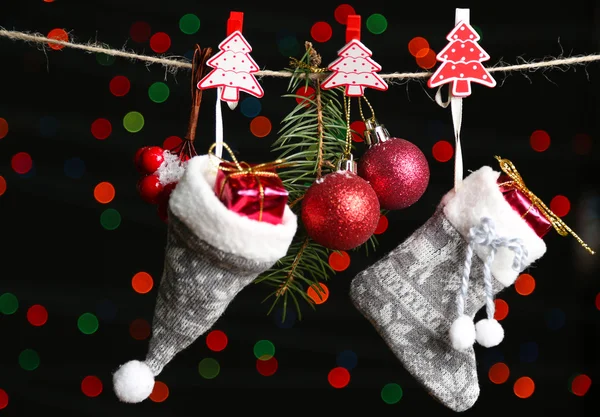 Calzino Babbo Natale, cappello e accessori natalizi su sfondo nero con luci — Foto Stock