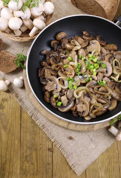 Heerlijke gebakken champignons in pan op tafel close-up — Stockfoto