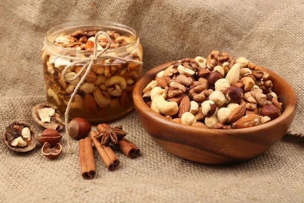 Sweet honey and different nuts on burlap — Stock Photo, Image